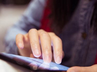 Frau lädt am Smartphone eine Webseite als PDF herunter.