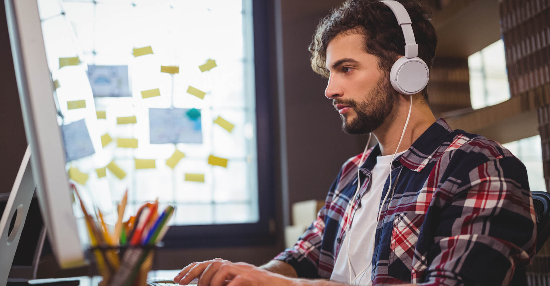 Junger Mann aktiviert den iTunes-Miniplayer am Mac, indem er drei Tasten drückt.