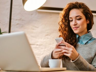 Frau nutzt Google Fotos auf Smartphone und Notebook