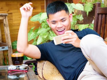 Junger Mann spielt einen Battle-Royale-Shooter auf dem Smartphone