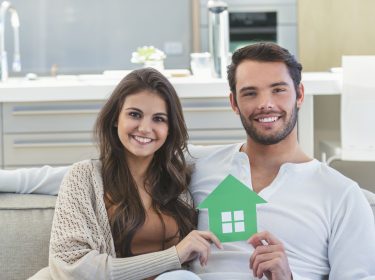 Paar hält kleines Haus in der Hand