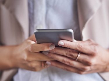 Frau passt am Smartphone in der Spark-App die Schriftart an.