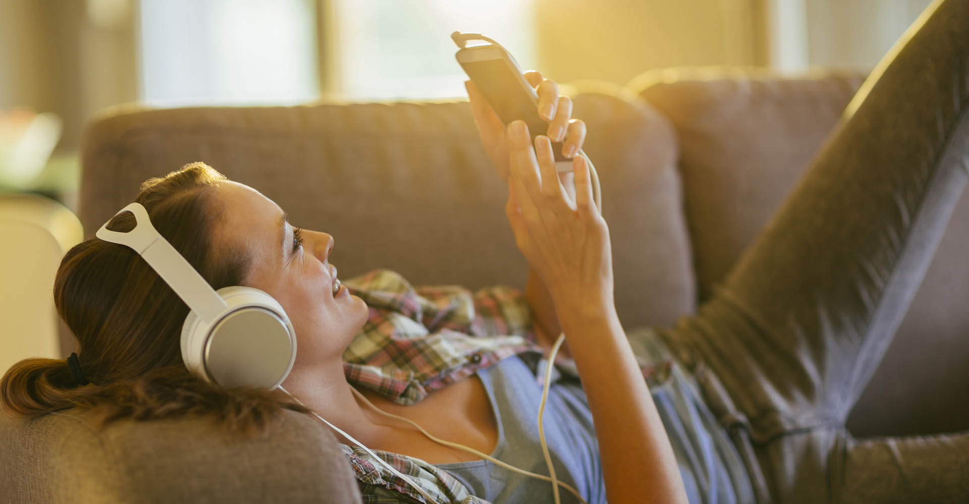 Junge Frau stellt am Smartphone ihre Deezer-Playlist ein.