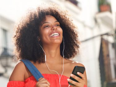 Junge Frau hat am Handy ihr Deezer-Problem gelöst und kann wieder Musik hören.