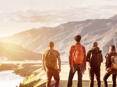 Vier Freunde vor einem Bergpanorama