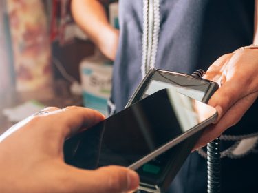 Eine Person bezahlt mit einem Smartphone