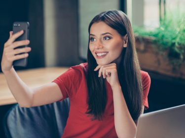 Frau scannt mit dem iPhone ihr Gesicht, um sich in die iCloud einzuloggen.