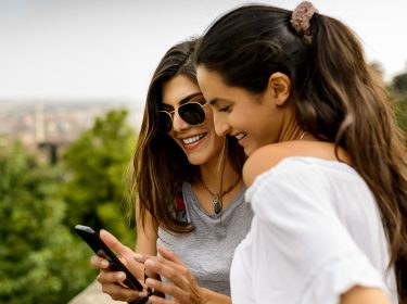 Zwei Frauen schauen sich etwas auf einem Smartphone an