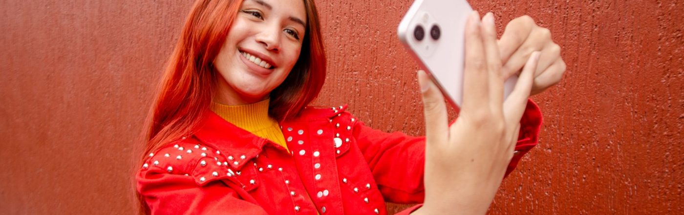 Frau nimmt Selfie von sich mit dem iPhone auf.