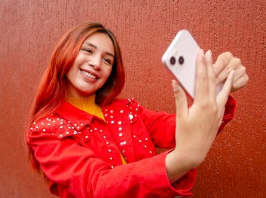 Frau nimmt Selfie von sich mit dem iPhone auf.