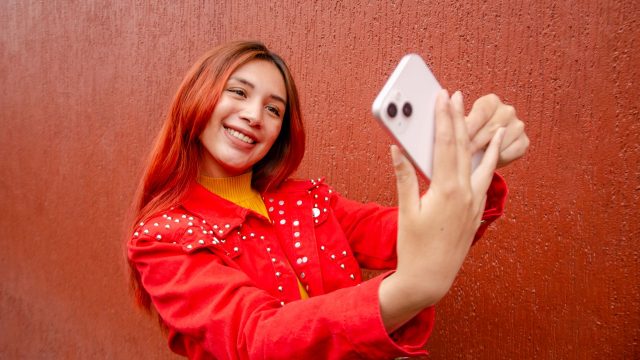 Frau nimmt Selfie von sich mit dem iPhone auf.