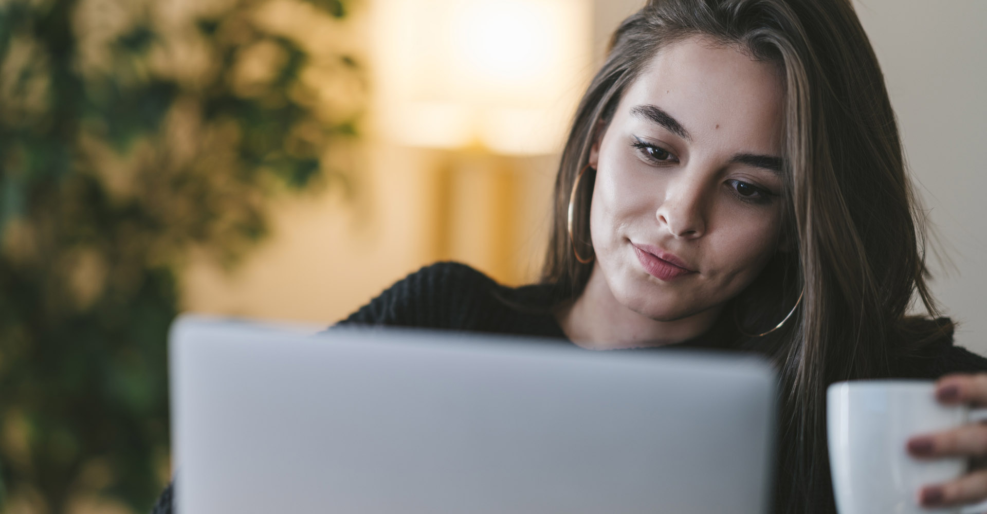 Junge Frau sucht am Laptop nach Netflix.