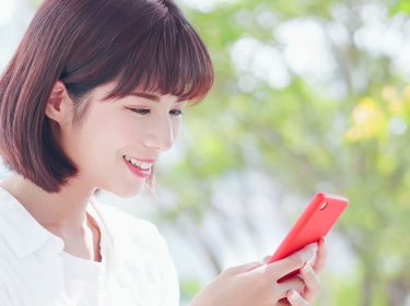 Junge Frau leert am Smartphone den WhatsApp-Speicher.