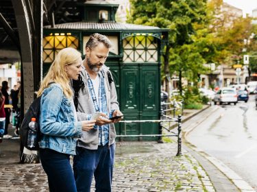 Paar sucht Ziel im Urlaub per Smartphone - Digitale Reiseführer als App