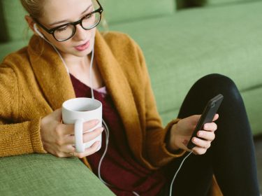 Frau migriert am Smartphone ihren Nest-Account zu Google.