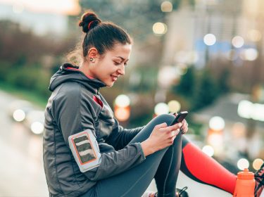 Frau mit Sportklamotten und Handy