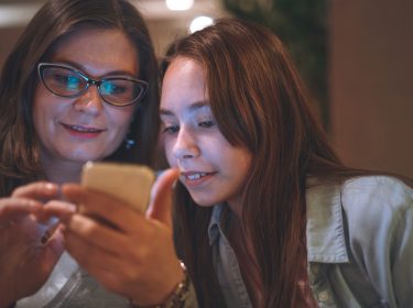 Mutter und Tochter am Handy