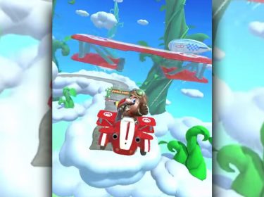 Mario fliegt in Mario Kart Tour mit seinem Kart durch die Luft und zeigt dabei den Daumen hoch