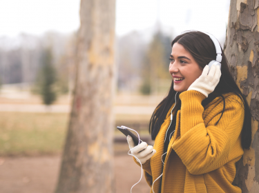 Frau hört via Smartphone einen empfehlenswerten Podcast.