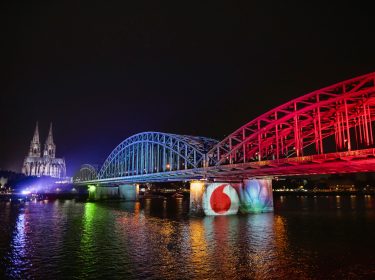 Brücke wird in den Farben von Vodafone und Unitymedia angeleuchtet in 
