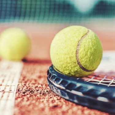 Nintendo Switch: Die besten Sport-Games Tennisball und Tennisschläger liegen auf dem Spielfeld.