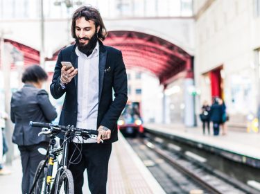 Mann mit Fahrrad nutzt den Inkognito Modus in Google Maps auf seinem Smartphone.