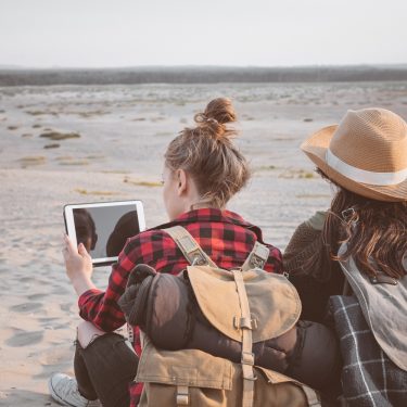Jugendreise Zwei Mädchen mit Tablet am Strand