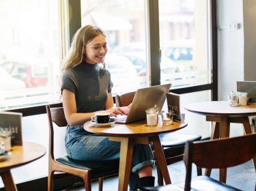Junge Frau mit Laptop im Cafe