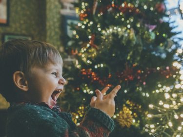 Junge vor Weihnachtsbaum