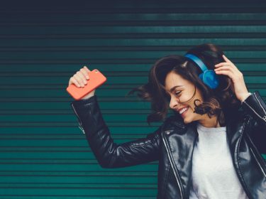 Frau mit Kopfhörer und Smartphone