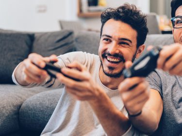 Zwei Männer zocken an der Konsole