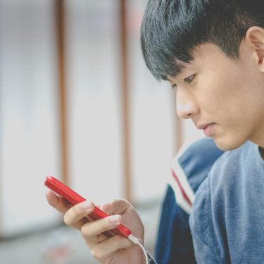 Ambient Mode für Google Assistant: So funktioniert er unter Android Junger Mann schaltet auf seinem Smartphone den Ambient Mode ein.