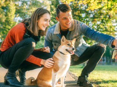 Paar nimmt Selfie mit Hund zum Teilen in Google Fotos auf.