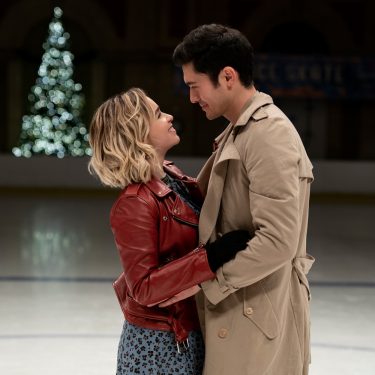 7 romantische Weihnachtsfilme zu Weihnachten Pärchen schaut sich in weihnachtlicher Kulisse verliebt an.