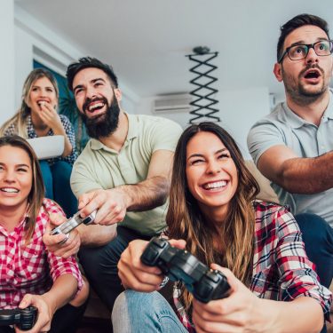 Group of friends play video games together.