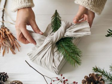 Ein Geschenk, das für nachhaltige Weihnachten in einem Leinentuch verpackt wurde.