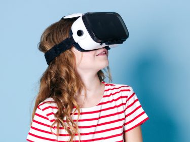 Junges Mädchen schaut sich mit einer VR-Brille digitale Mutmacher an