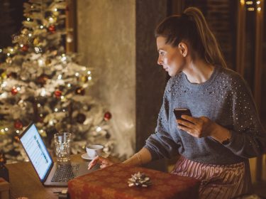 Eine Frau sitzt am Laptop umWeihnachtsgeschenke zu tauschen