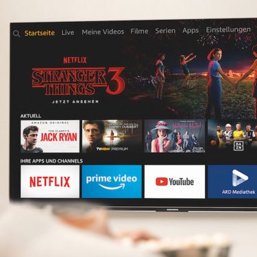 Den Amazon Fire TV Stick zurücksetzen Junge Frau steuert den Amazon Fire TV.