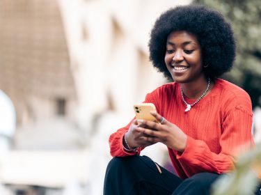 Frau mit Smartphone nutzt eSIM-Push