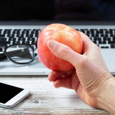 welchen-Mac-habe-ich Macbook mit Hand und Apfel