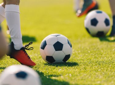 Spieler spielen Fußball auf dem Platz.