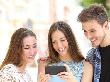 Freunde schauen auf ein Smartphone