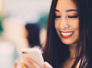 Frau öffnet den neuen Facebook Messenger am Handy.