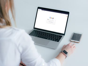 Eine Frau führt an ihrem Laptop eine Google-Bilder-Rückwärtssuche durch