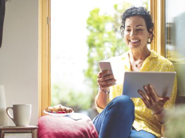 Frau nutzt WhatsApp auf Smartphone und Tablet.