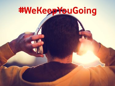 Man von hinten mit Kapuzenpulli und Kopfhörern hört Wissens-Podcasts