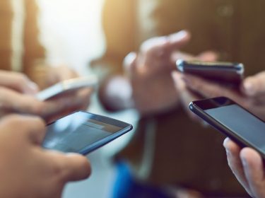 Freunde übertragen Daten von Handy zu Handy.