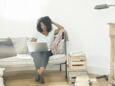 Frau mit Laptop auf der Couch