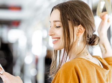 Frau mit Smartphone in U-Bahn